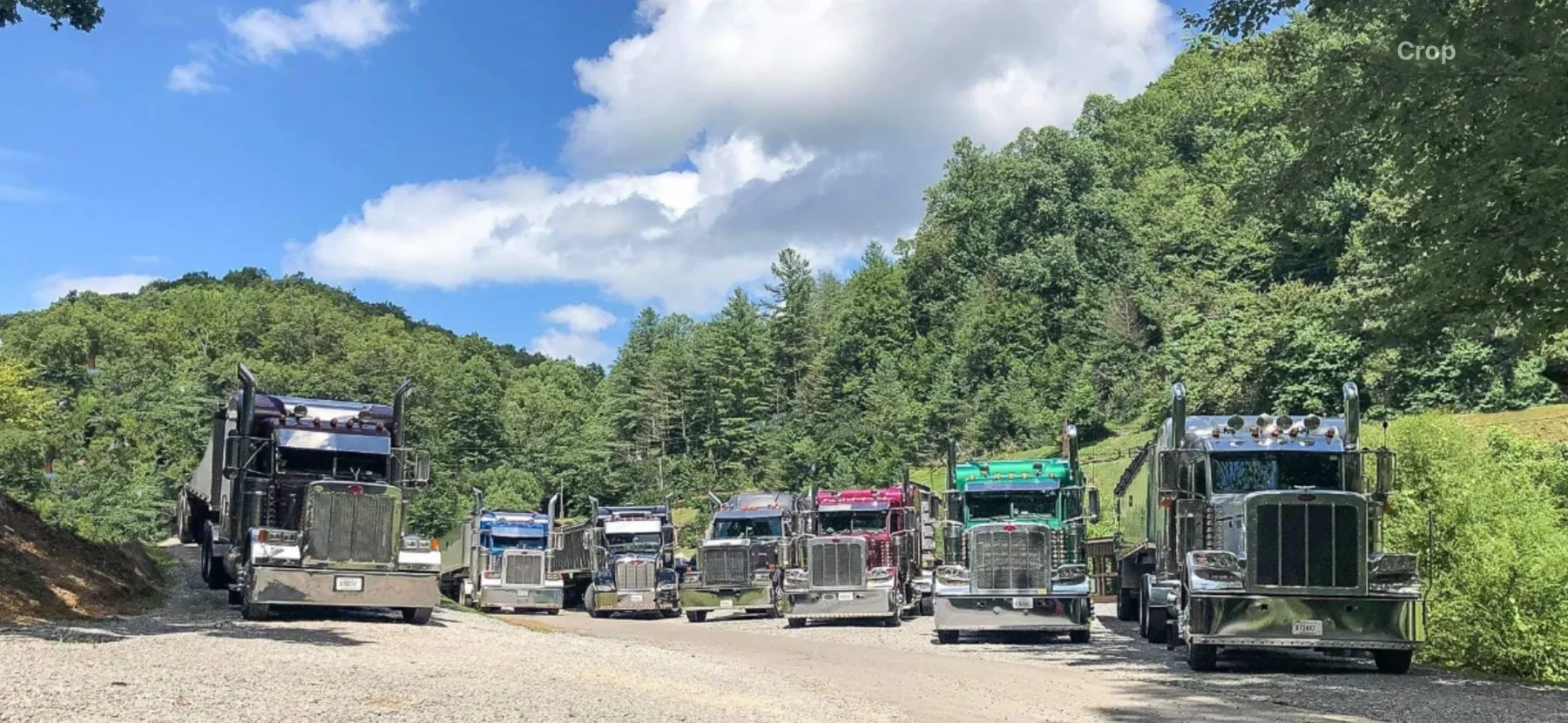 Lineup of commercial trucks in a wooded mountain setting